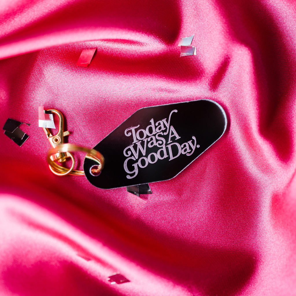 mirrored motel keyring etched with "Today was a good day" over pink silk