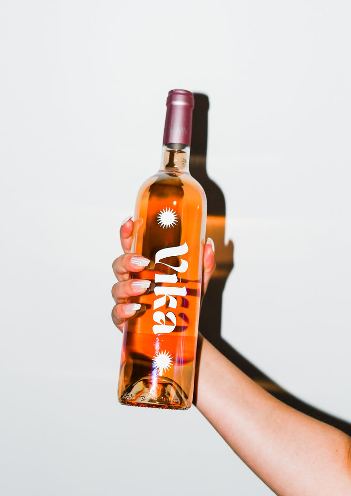 hand holding personalised bottle of rose, vika
