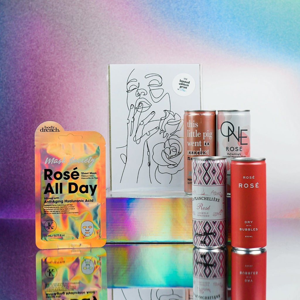 4 cans of rose', a rose all day face mask and a gold foil print of line drawing of a girl with two roses. The pink gift card sits on top which reads "you deserve Roses every day