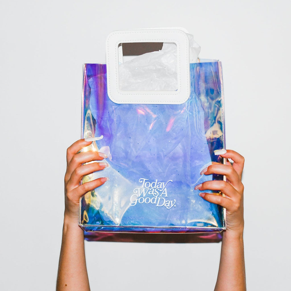 two hands holding up holographic gift bag, today was a good day