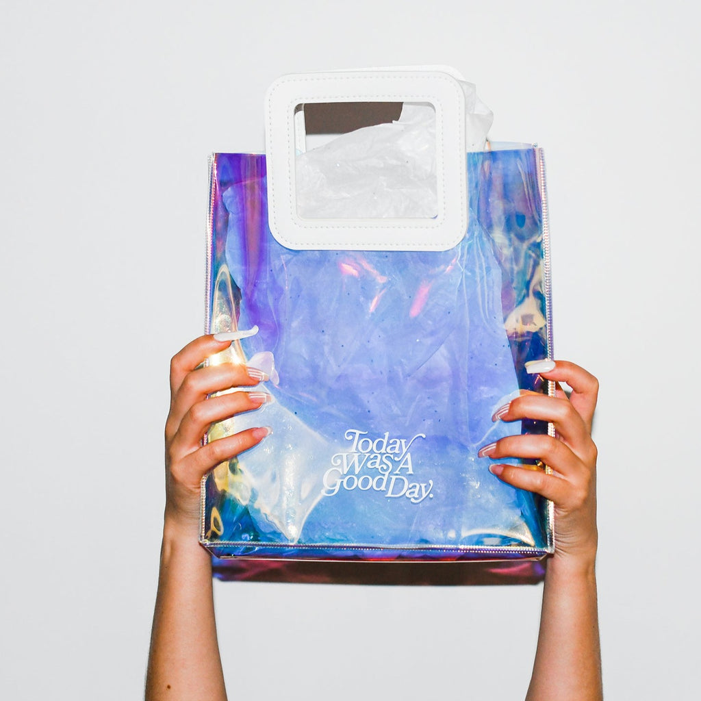 two hands holding up holographic bag that says Today was a good day